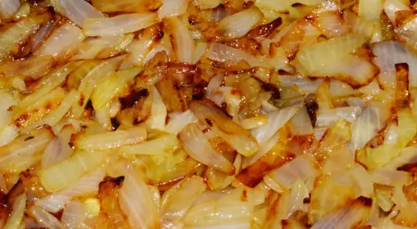 Smażona cebula, składnik zdrowej diety na stłuszczoną wątrobę, apetycznie skarmelizowana.